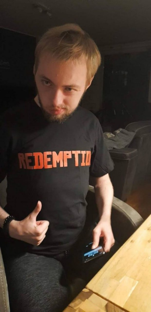 Мужчина показывает палец вверх в комнате за столом