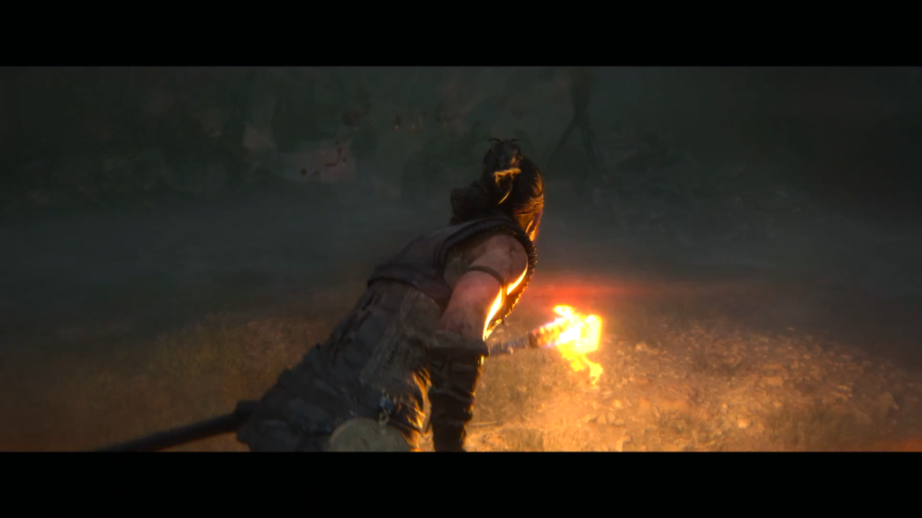 Сенуа из Hellblade держит горящий факел в тумане
