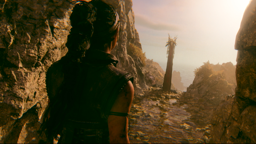 Сенуа из Hellblade стоит на тропе у моря