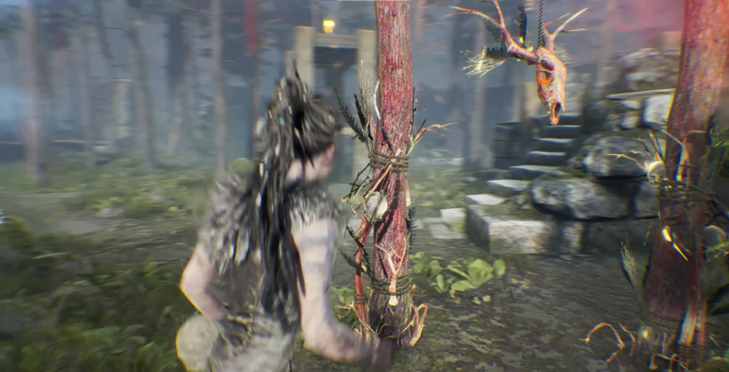 Сенуа из Hellblade стоит у тотема в лесу