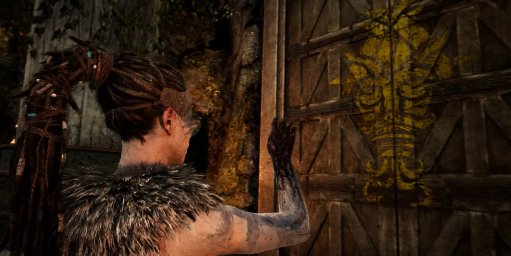 Сенуа из Hellblade открывает деревянную дверь с символом