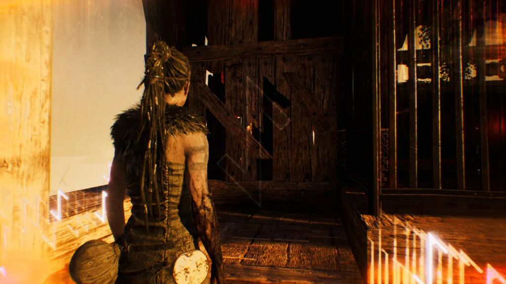 Сенуа из Hellblade стоит у деревянной двери