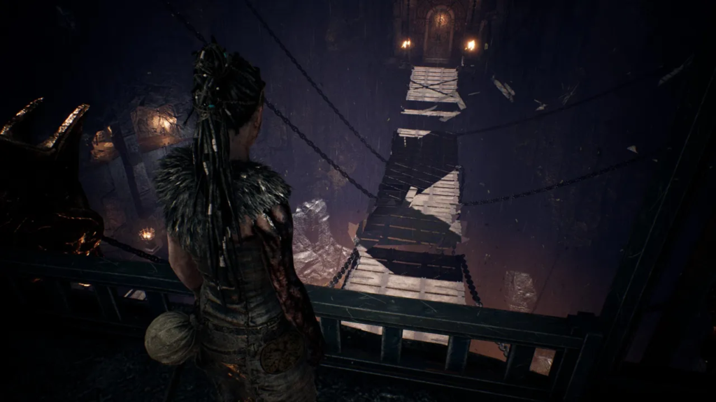 Сенуа из Hellblade смотрит на подвесной мост в пещере