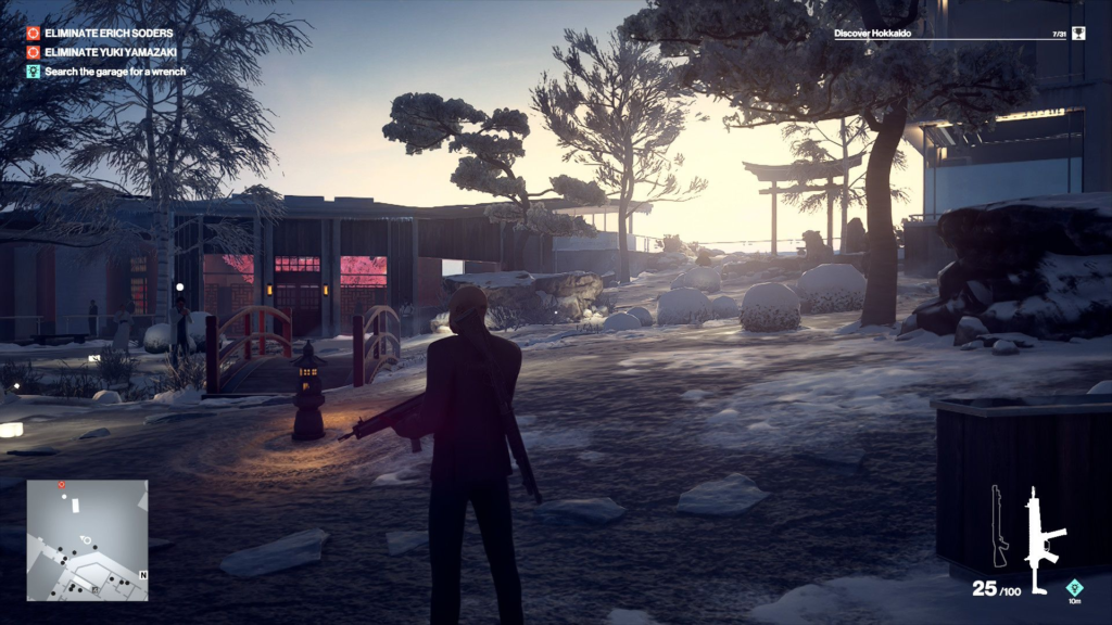 Агент 47 из Hitman стоит в заснеженном саду