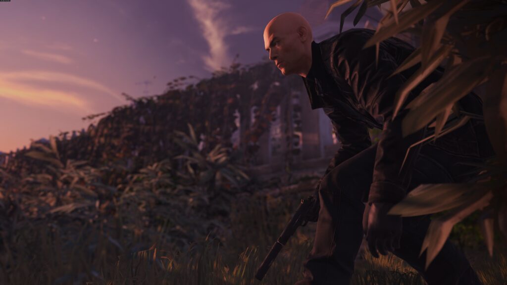 Агент 47 из Hitman присел в траве с пистолетом