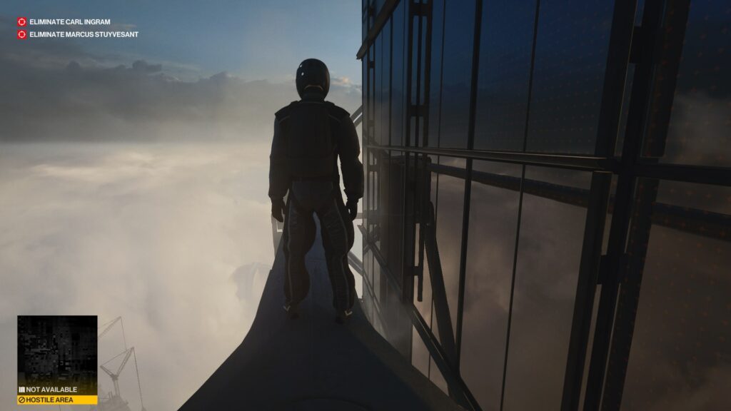 Агент 47 из Hitman стоит на крыше небоскрёба